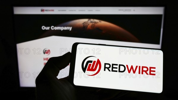 Stuttgart, Germany, 09-04-2022: Person holding mobile phone with logo of American aerospace company