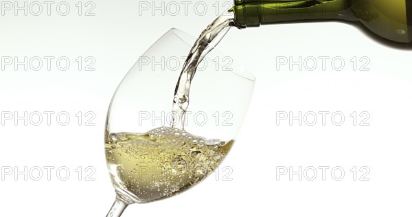 White Wine being poured into Glass, against White Background