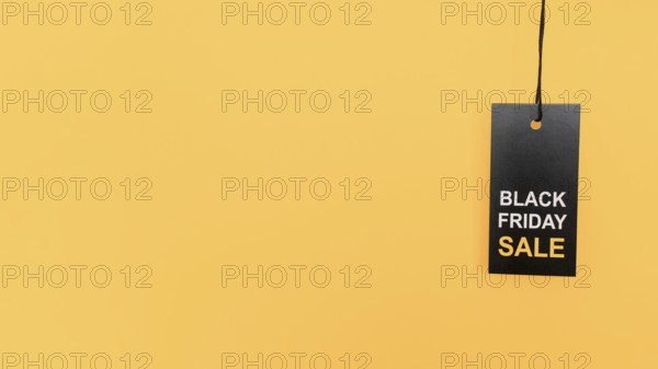 Hanging red black friday sale label copy space yellow background