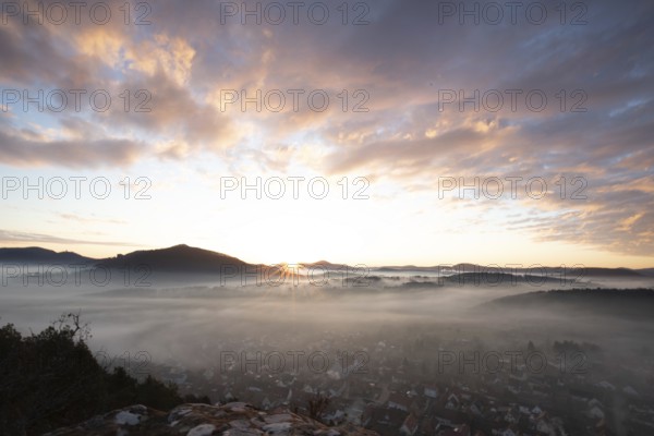 Mystical sunrise at the Wachtfelsen. Fascinating landscape shot between fog and clouds near