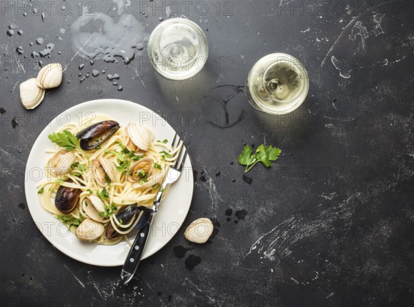 Spaghetti vongole, Italian seafood pasta with clams and mussels, in plate with herbs and two