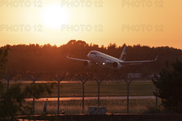 Passenger aircraft Airbus A320neo of the airline Eurowings in the evening glow during approach to