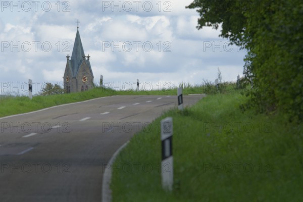 Country road with a view of the village church in Bibersfeld, Swabian-Franconian Forest nature park