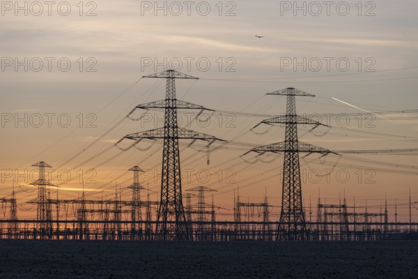 Rows of high-voltage pylons stretch into the twilight, Wolmirstedt substation, Saxony-Anhalt,