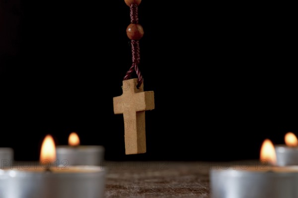 Circle of lighted candles with a wooden Rosary praying beads in the center and a smoldering incense