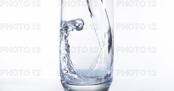 Water being poured into Glass against White Background
