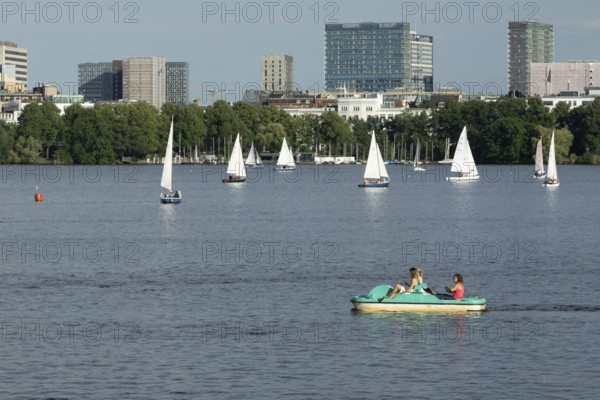 Symbolic picture weather, leisure activities in summer, people in a pedal boat, behind them sailing