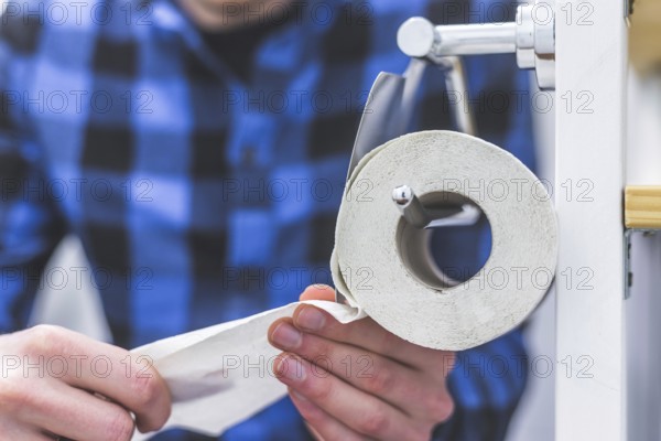 Hand of a male person using toilet paper