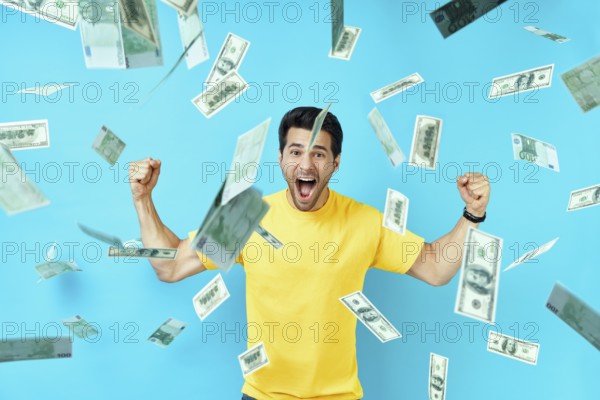 Happy excited man standing under money rain banknotes falling down. Success, business, and fortune