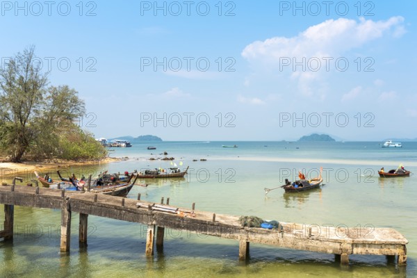 Locals on the beach and on their long-tail boats at the west side beach Ao Mae Mai on the island Ko