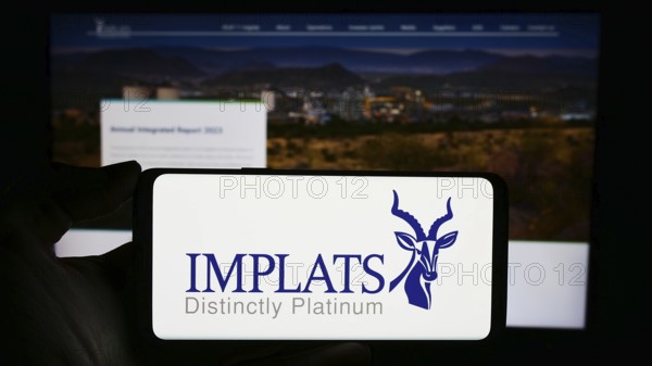 Stuttgart, Germany, 12-07-2023: Person holding cellphone with logo of company Impala Platinum