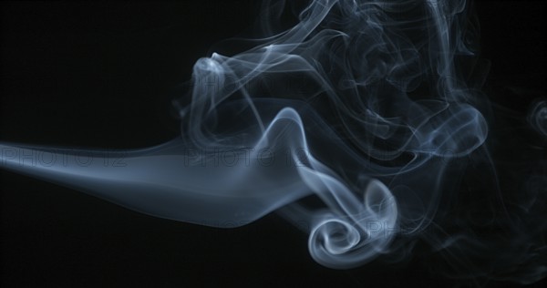 Smoke of Cigarette rising against Black Background