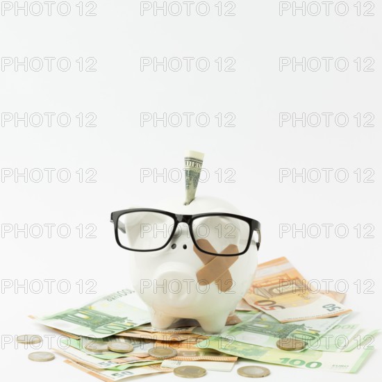 Broken piggy bank wearing glasses
