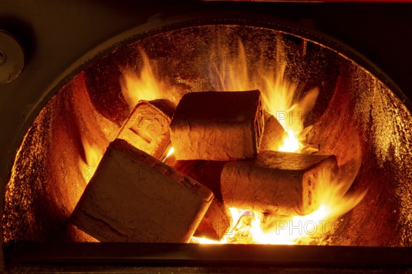 Wood briquettes (ruf type), made of beech and oak burning inside the wood fuel boiler. Alternative