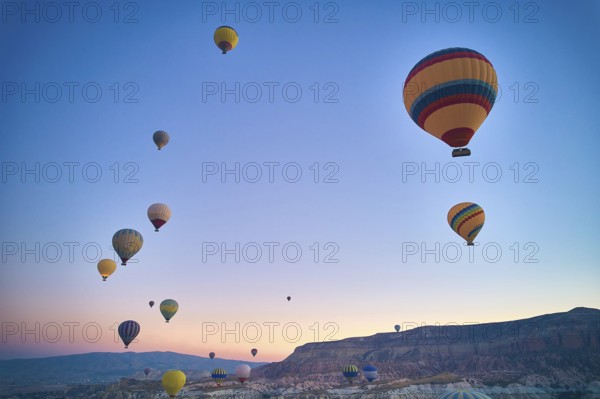 Lots of hot air balloons above fairy chimneys rock formations. Aerial view of Cappadocia. Goreme,