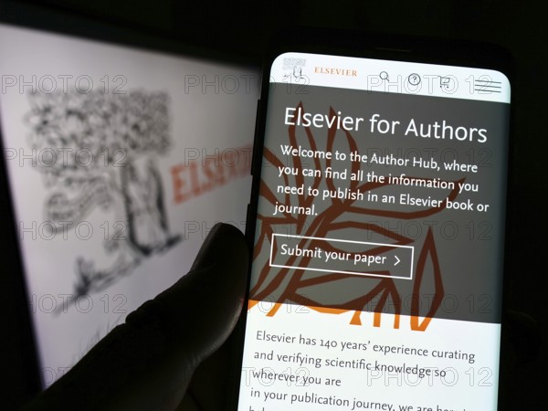 Stuttgart, Germany, 07-31-2022: Person holding smartphone with website of academic publishing