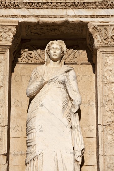 Ancient marble statue of a woman looks out under intricate archway copy space (statue is Sophia)