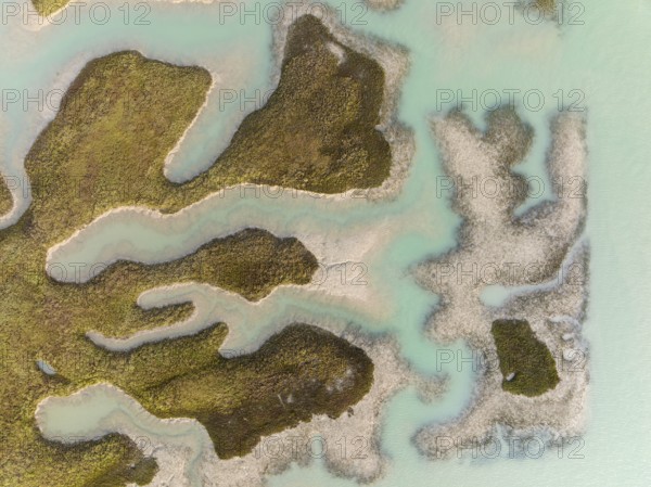 Patches of land appear while the tide is going out, in the marshland of the Bahía de Cádiz, aerial