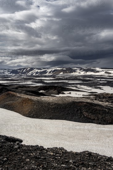 Snow-covered volcanic landscape with volcanic sand and petrified lava, crater of Askja volcano,