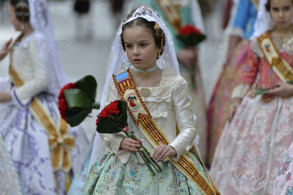 Fallas festival, girls in a traditional costume during the parade in the Plaza de la Virgen de los
