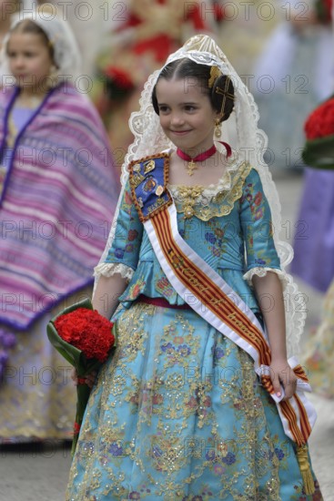 Fallas festival, girl in a traditional costume during the parade in the Plaza de la Virgen de los