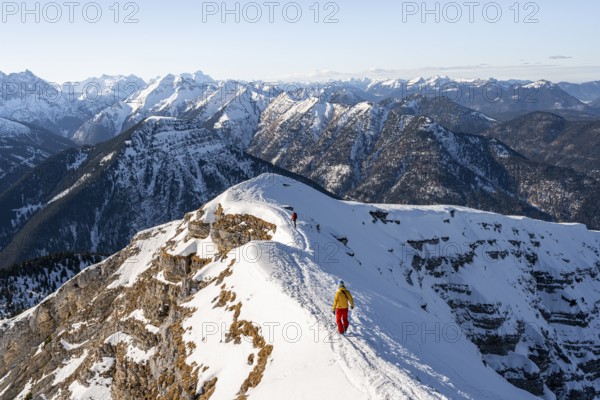 Two ski tourers at the summit of Schafreuter, view of snowy mountain panorama, Karwendel, Tyrol,