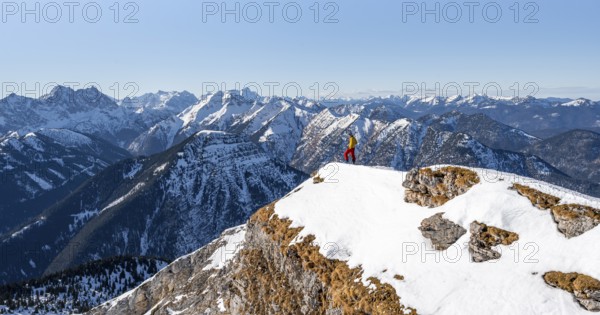 Ski tourers at the summit of Schafreuter, view of snowy mountain panorama, Karwendel, Tyrol,