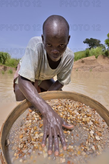 Diamond hunter searching for diamonds with a sieve, near Koidu, Koidu-Sefadu, Kono District,