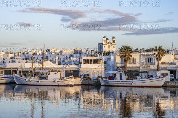 View of Naoussa, Fishing boats in the harbour at sunset, reflected in the sea, White Cycladic