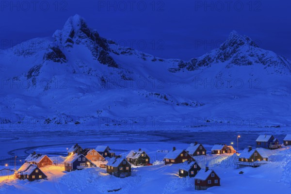Inuit settlement, houses in deep snow in front of mountains, blue hour, twilight, winter, Tasiilaq,