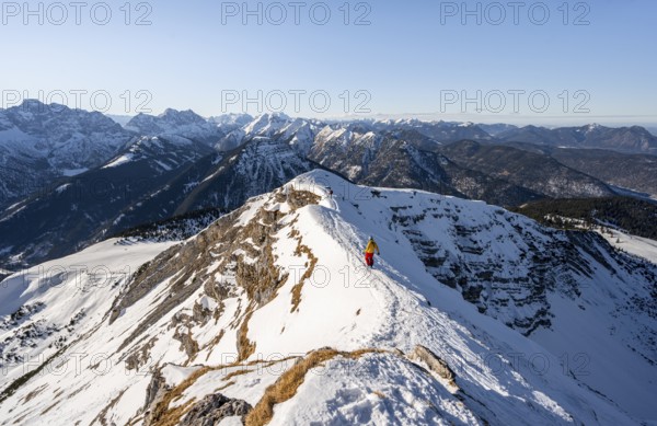 Ski tourers at the summit of Schafreuter, view of snow-covered mountain panorama, Karwendel, Tyrol,