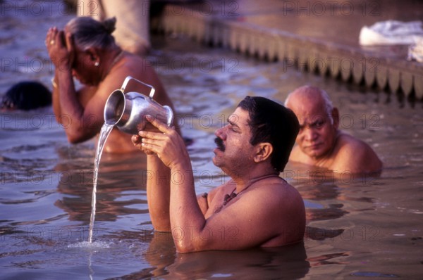 A Pilgrim pays homage to the Mother of River Ganga Ganges Ghats at Varanasi Benaras, Uttar Pradesh,