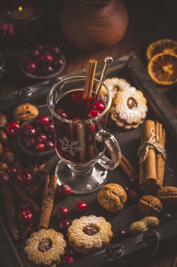 Mulled wine with cranberry and spices, Christmas cookies and candles