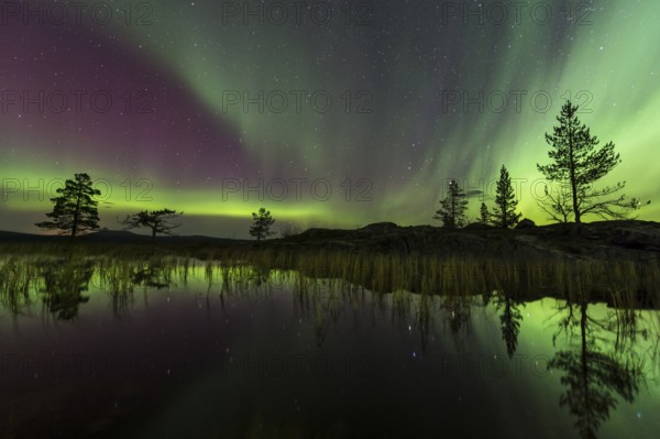 Northern Lights (Aurora borealis) reflected in a mountain lake, Gällivare, Norrbotten, Lapland,