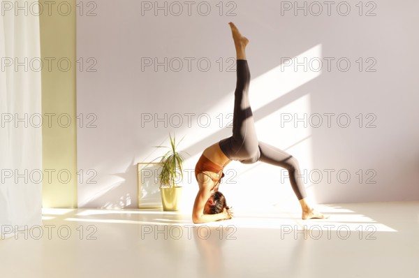 Side view of calm female in sportswear practicing yoga in Firefly pose while balancing on arms on