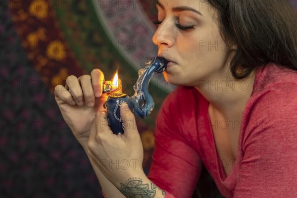 A beautiful brunette model smokes marijuana in the privacy of her own home