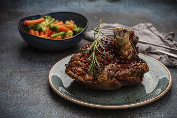 Delicious roasted ham or pork knuckle with glazed brown crispy skin, red pepper berries and