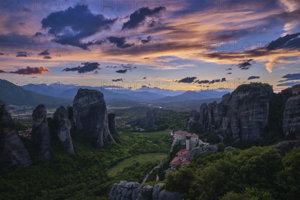 Twilight view of Meteora valley. Valley in last moments of sunlight, hazy distant mountains,