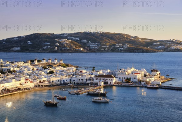 Beautiful sunset view over Chora, main town of Mykonos, Cyclades, Greece and its harbor and port.