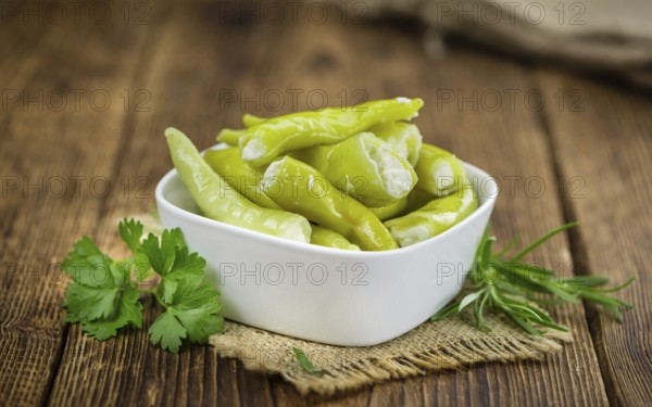 Fresh made Green Chilis (filled with cheese) on an old and rustic wooden table (selective focus,