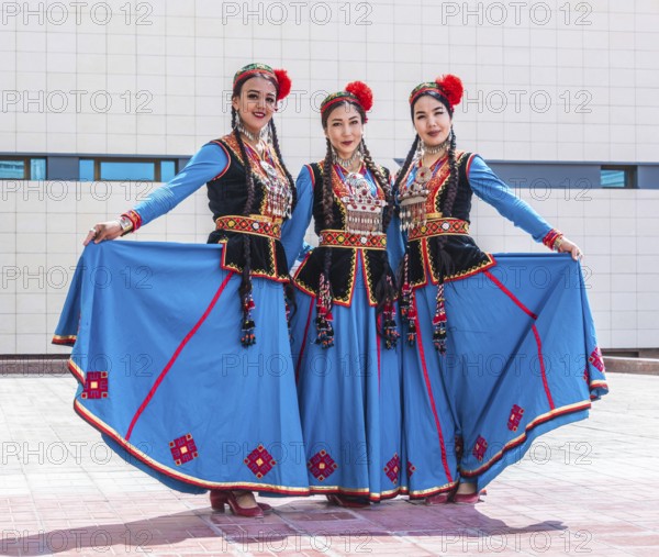 NUKUS, UZBEKISTAN - MAY 6, 2019: Three traditionally dressed folk dancers in Nukus, Uzbekistan,