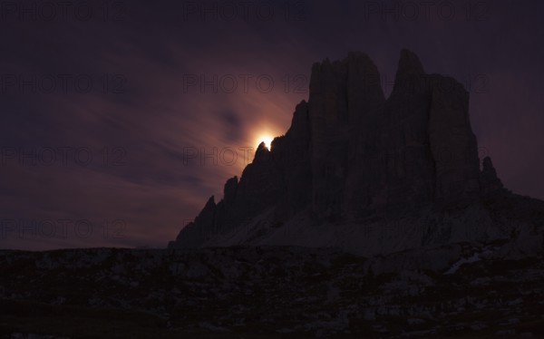 Setting full moon on the edge of the smaller Three Peaks, Hochpustertal valley, Sexten, South Tyrol