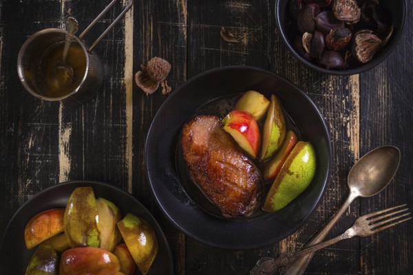 Roasted duck breast with golden crispy skin served with baked apples and chestnuts. Served on a