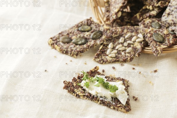 Healthy snacks from linseed, oat, herbs and various seeds, one with cream cheese and parsley