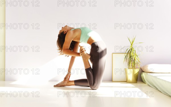 Side view of calm female in sportswear practicing yoga in Firefly pose while balancing on arms on