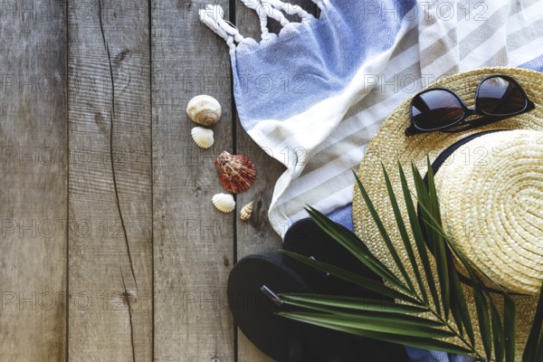 Concept of travel, vacation or weekends. Straw hat with palm leaf, shoes and eyeglasses, towel on