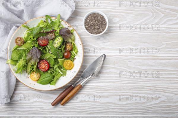 Vegetables vegetarian healthy salad with red yellow cherry tomatoes, green leafs and chia seeds on