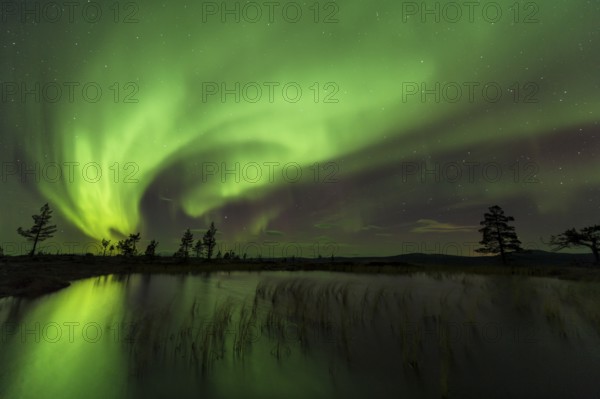 Northern Lights (Aurora borealis) reflected in a mountain lake, Gällivare, Norrbotten, Lapland,