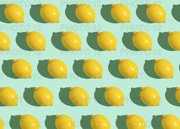 Fresh yellow whole lemons on minimal blue background on bright sun light with hard shadows pattern