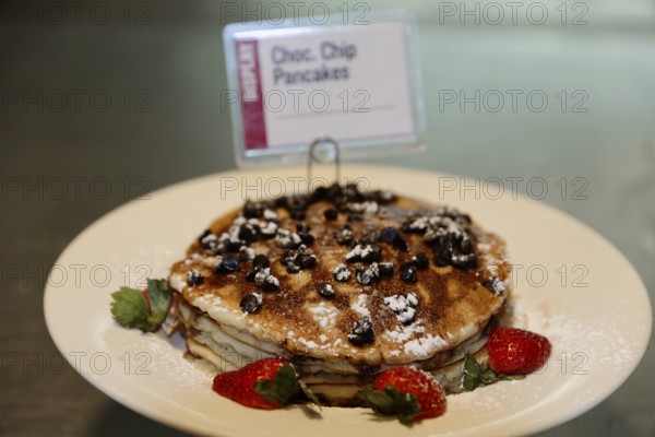 Pancakes with Oreo biscuit pieces and strawberries, sprinkled with icing sugar, Manhattan, New York